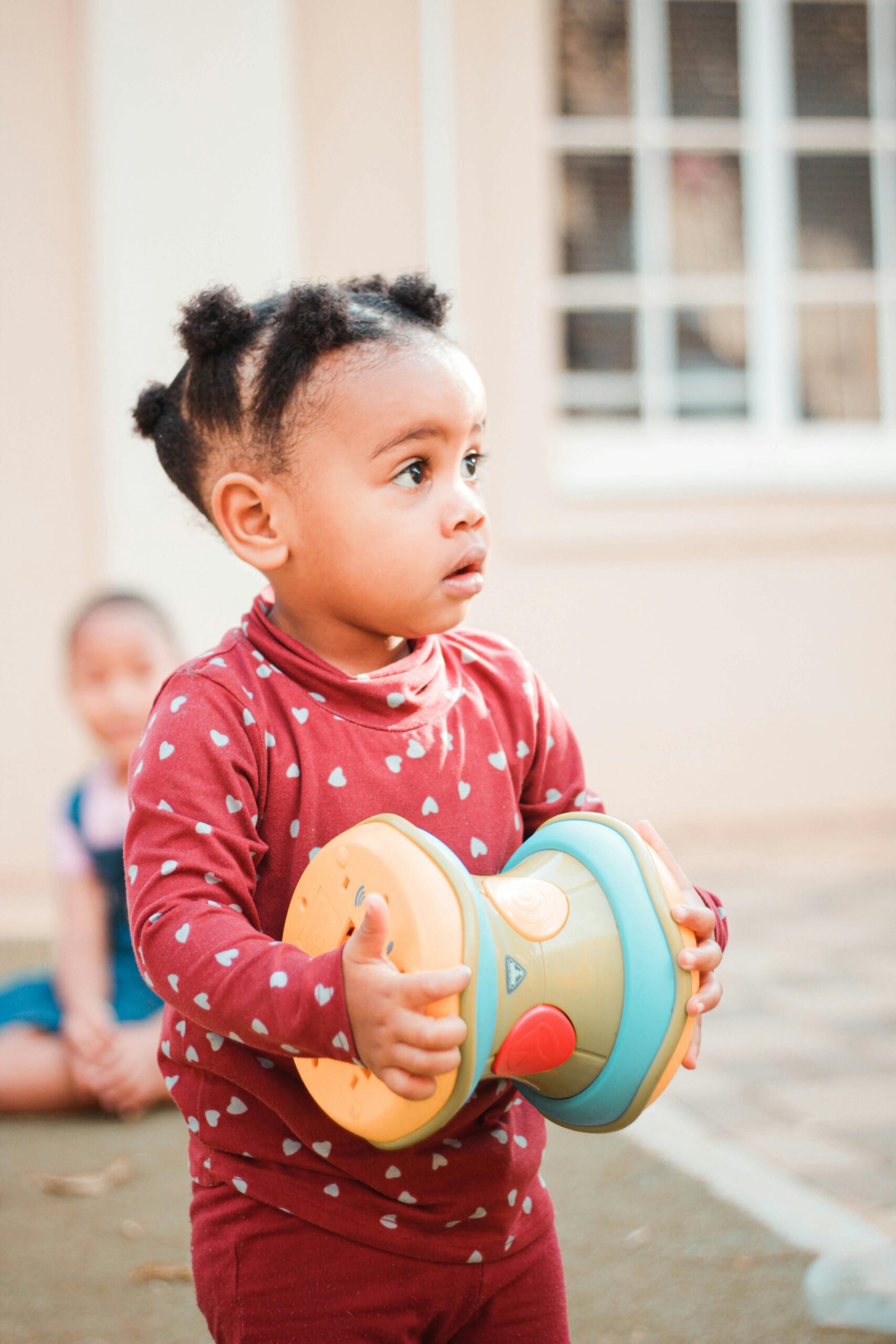 Adorable child holding a toy indoors